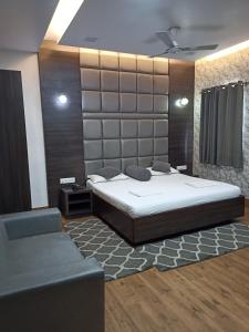a bedroom with a large bed and a couch at Hotel Alka in Varanasi
