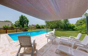 a patio with white chairs and a swimming pool at Nice Home In Mareuil En Perigord in Cercles +21 photos