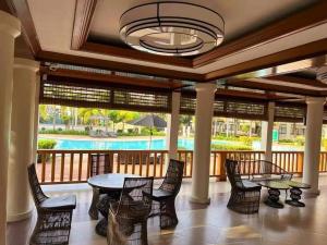 a dining room with a table and chairs and a pool at 1bedroom one oasis condo fullyfurnished in Davao City