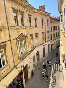 a group of people walking down a street at Dejan Apartments-Top centar-Old town-Low budget Studios in Pula