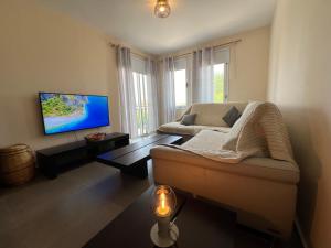 a living room with a couch and a flat screen tv at Sea-View Eco-Apartment B110 in Polis Chrysochous