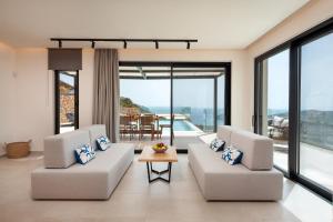 a living room with two white couches and a table at Villa Cristina in Elounda