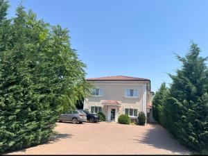 a house with two cars parked in a driveway at Armonia Apartments in Timişoara