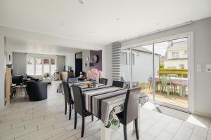 a dining room with a table and chairs and a living room at Kermat in Matignon +16 photos