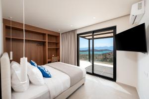 a bedroom with a large bed with a large window at Villa Cristina in Elounda