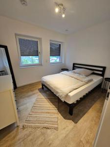 a bedroom with a bed with a rug and two windows at Stilvoll-möbliertes Apartment in Harsefeld