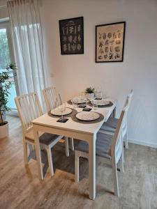 a dining room table with chairs and a white table and chairsktop at Stilvoll-möbliertes Apartment in Harsefeld