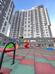 a playground in front of a large building at Premium Lux Apartament Center Botanica in Chişinău