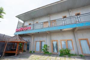a building with a balcony on top of it at RedDoorz Syariah near Lombok Epicentrum Mall in Mataram
