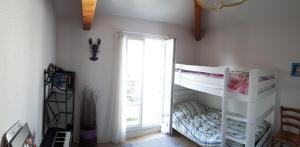 a bedroom with a white bunk bed and a window at Maison 6P dans résidence avec piscine in Châtelaillon-Plage