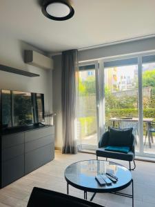 un salon avec un canapé et une table en verre dans l'établissement 7th Sense boutique apartments, à Sofia