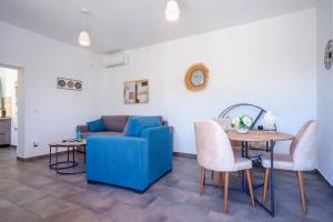 a living room with a blue couch and a table at Villa Spirida at Drakopoulata in Agia Effimia