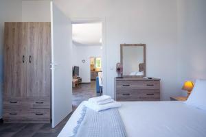 a bedroom with a large white bed and a mirror at Villa Spirida at Drakopoulata in Ayia Evfimia +18 photos