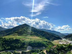 a view of a mountain under a cloudy sky at Qafoku GuestHouse in Çorovodë