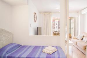 a bedroom with a bed and a couch and a mirror at Serisol Holidays in Benidorm +16 photos
