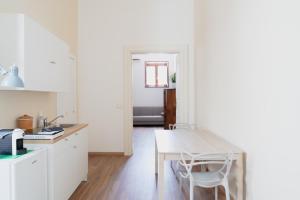 a white kitchen with a table and chairs at Terravecchia B&B in Sarno