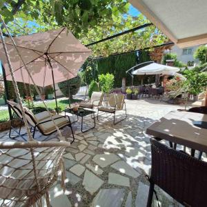a patio with chairs and tables and an umbrella at Apartments Chemenko in Konsko