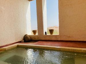 a pool of water in a building with a window at DAR INFIANE Tata in Tatta