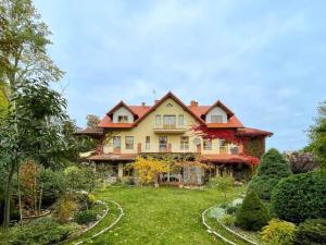 a large house with a garden in front of it at Pokoje Łabędź in Dziwnów