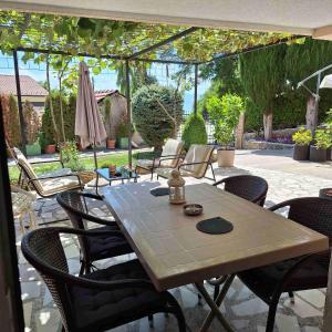 a patio with a table and chairs and an umbrella at Apartments Chemenko in Konsko