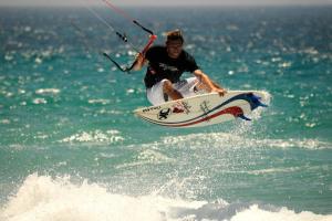 a man riding a wave on a surfboard in the ocean at Bungalows Tangana in Tarifa
