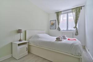 a white bedroom with a bed and a window at Welcome to Karl House in Champigny-sur-Marne