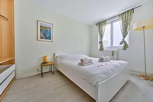 a white bed in a room with a window at Welcome to Karl House in Champigny-sur-Marne +6 photos