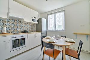 a kitchen with a table and chairs in a kitchen at Welcome to Karl House in Champigny-sur-Marne