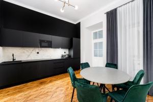 kuchnia i jadalnia ze stołem i zielonymi krzesłami w obiekcie Wawel Boutique Residence - Krakow Old Town w Krakowie