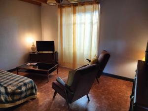 a living room with two chairs and a bed and a table at Maison Vintage in Marat
