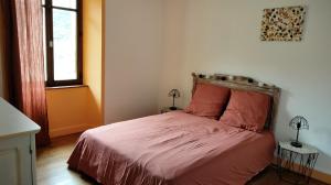 a bedroom with a bed with pink sheets and a window at Maison Vintage in Marat