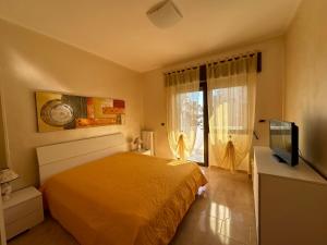 a bedroom with a bed and a tv and a window at Dimora Signore Gallipoli lido in Gallipoli
