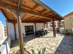 an outdoor patio with a wooden pergola at Dimora Signore Gallipoli lido in Gallipoli