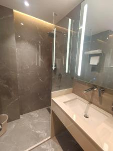 a bathroom with a sink and a shower with a mirror at Wingston A TreeHouse Hotel, Mathura in Mathura