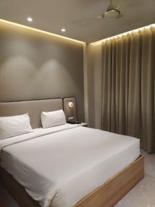 a bedroom with a large bed with white sheets at Wingston A TreeHouse Hotel, Mathura in Mathura