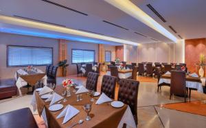a restaurant with tables and chairs in a room at Wingston A TreeHouse Hotel, Mathura in Mathura