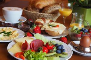 a table topped with plates of food with fruit and bread at Hotel Nothnagel in Darmstadt