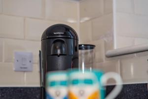 a coffee maker sitting on a counter next to a cup at Two bedroom Newcastle City Quayside Apartment in Newcastle upon Tyne