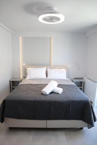 a bedroom with a bed with a black comforter at Golden Sand Suites in Anavissos