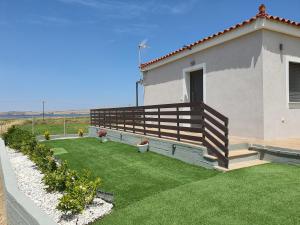 a house with a deck and a yard with grass at Island View Apartments in Moúdhros
