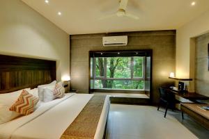 a bedroom with a bed and a desk and a window at SANKAMA The Boutique Hotel in Dāvangere