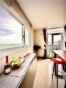 a kitchen with a counter with a window and a table at Luxurious Deluxe Apartment - EhubStay Mactan Cebu - Saekyung Condo Looc in Lo-oc