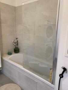 y baño con bañera y ducha acristalada. en Superbe appartement chic et calme, en Clamart