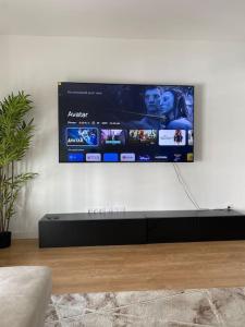TV colgada en la pared de la sala de estar en Superbe appartement chic et calme, en Clamart
