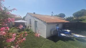 a small house with a blue chair in a yard at Maisonnette avec jardin et piscine privée in Grabels