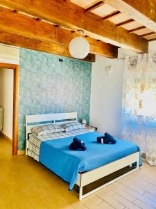 a bedroom with a blue bed with two black shoes on it at Residenza La Rotonda in Vasto