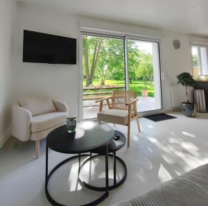 a living room with a couch and a table at Le Lodge de St Sauveur in Esquennoy