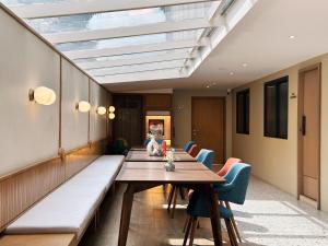 a dining room with a long table and blue chairs at Parcel Hotel Bangkok in Bangkok