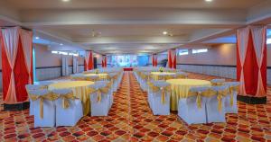 a banquet hall with yellow tables and yellow chairs at Wingston A TreeHouse Hotel, Goverdhan in Govardhan +8 photos