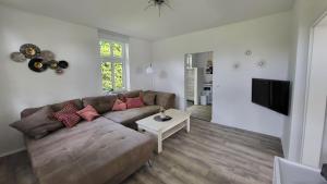 a living room with a couch and a table at Ferienwohnung Emma s Fehnhaus, 55183 in Stickhausen
